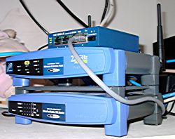 [Ethernet hub, Wi-Fi access point, broadband router, and cables on a shelf]]